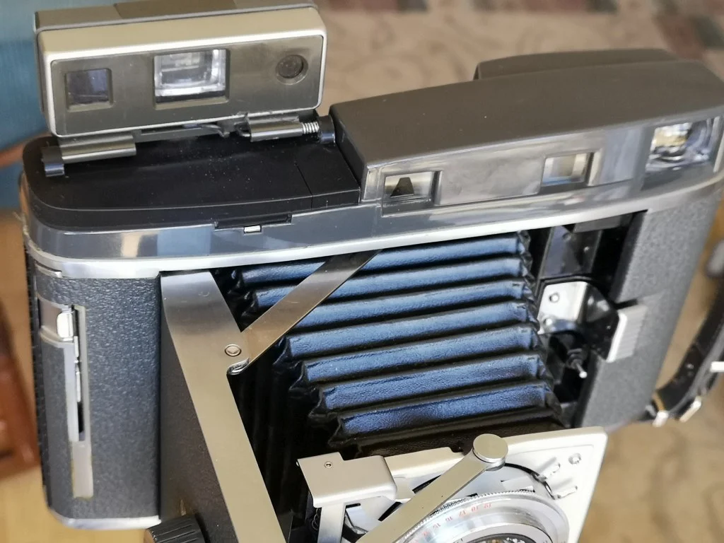Polaroid roll film camera viewfinder mount
