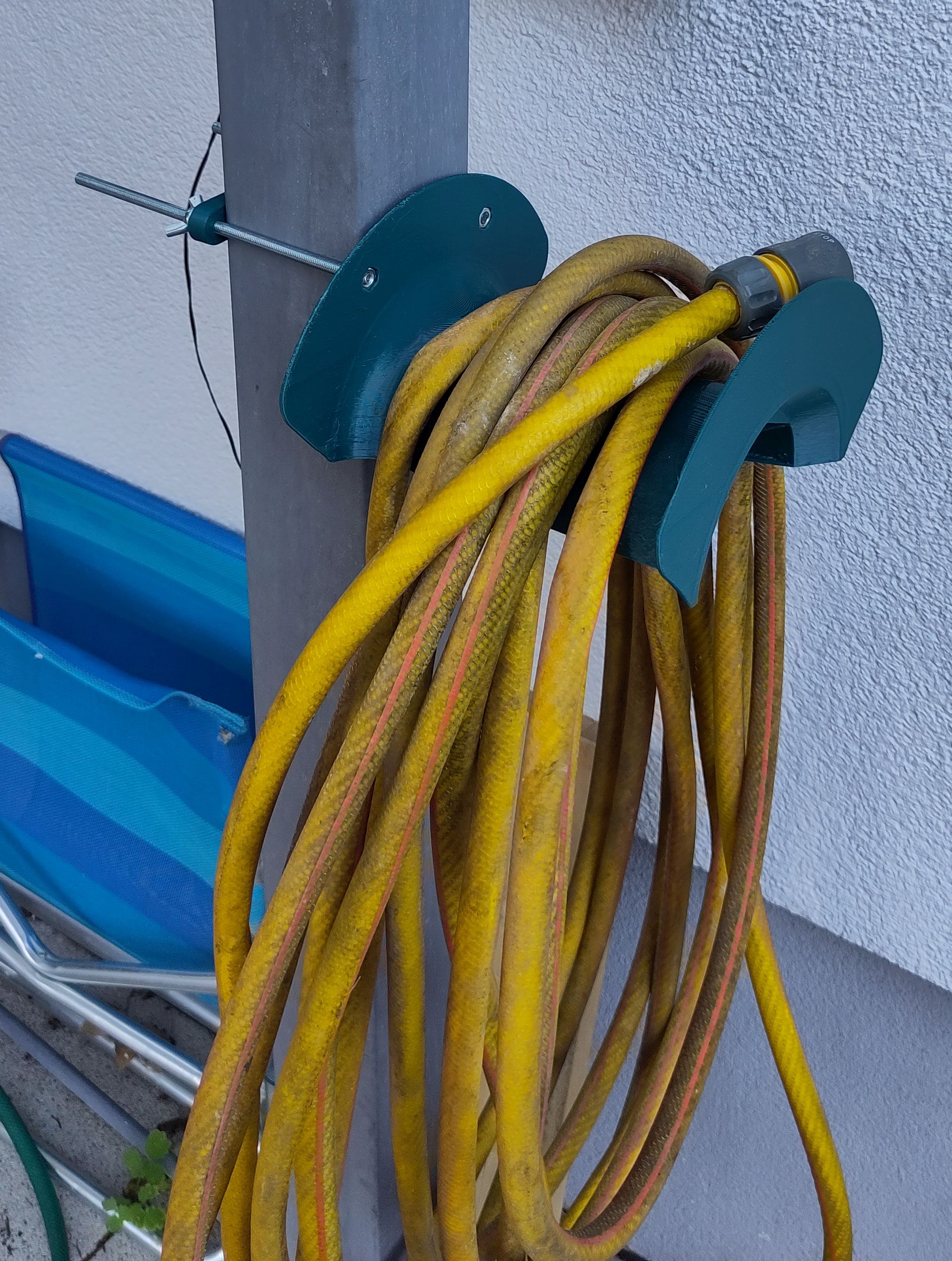 Garden hose holder to mount against a post or a wall