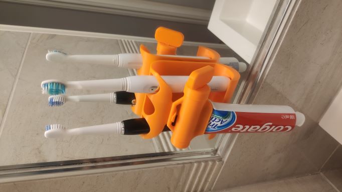 Toothpaste squeezer and toothbrush holder