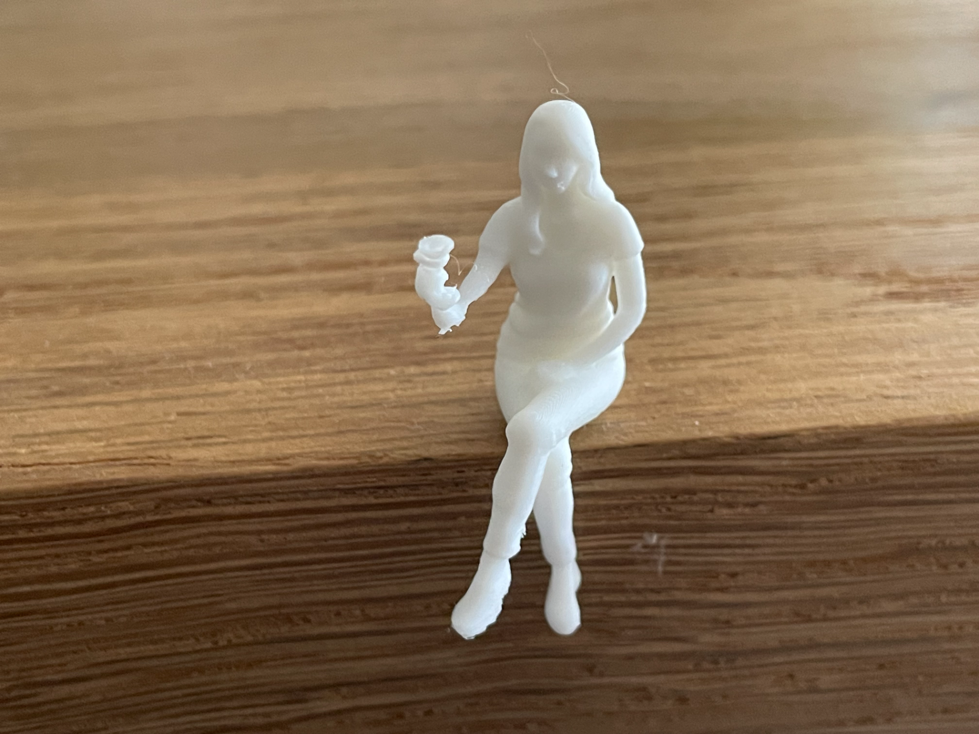 Kleine sitzende Frau mit Weinglas