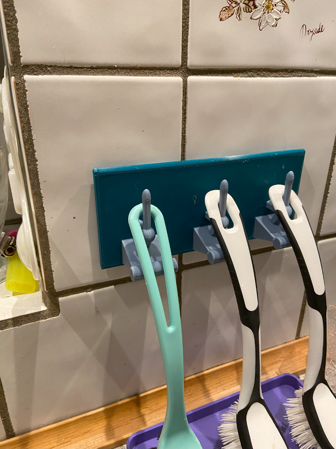 Brush hanger for kitchen sink wall