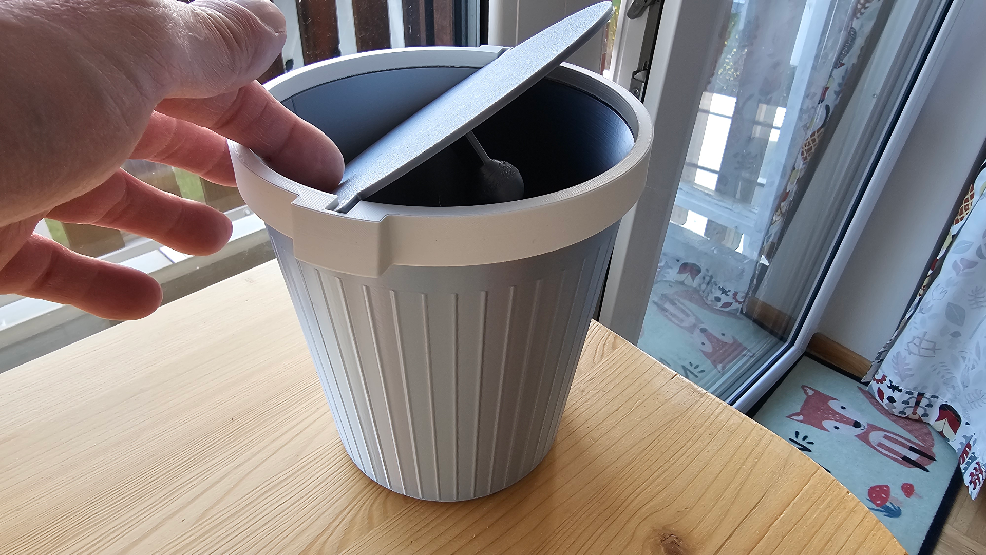 Bin with weighted flip Lid