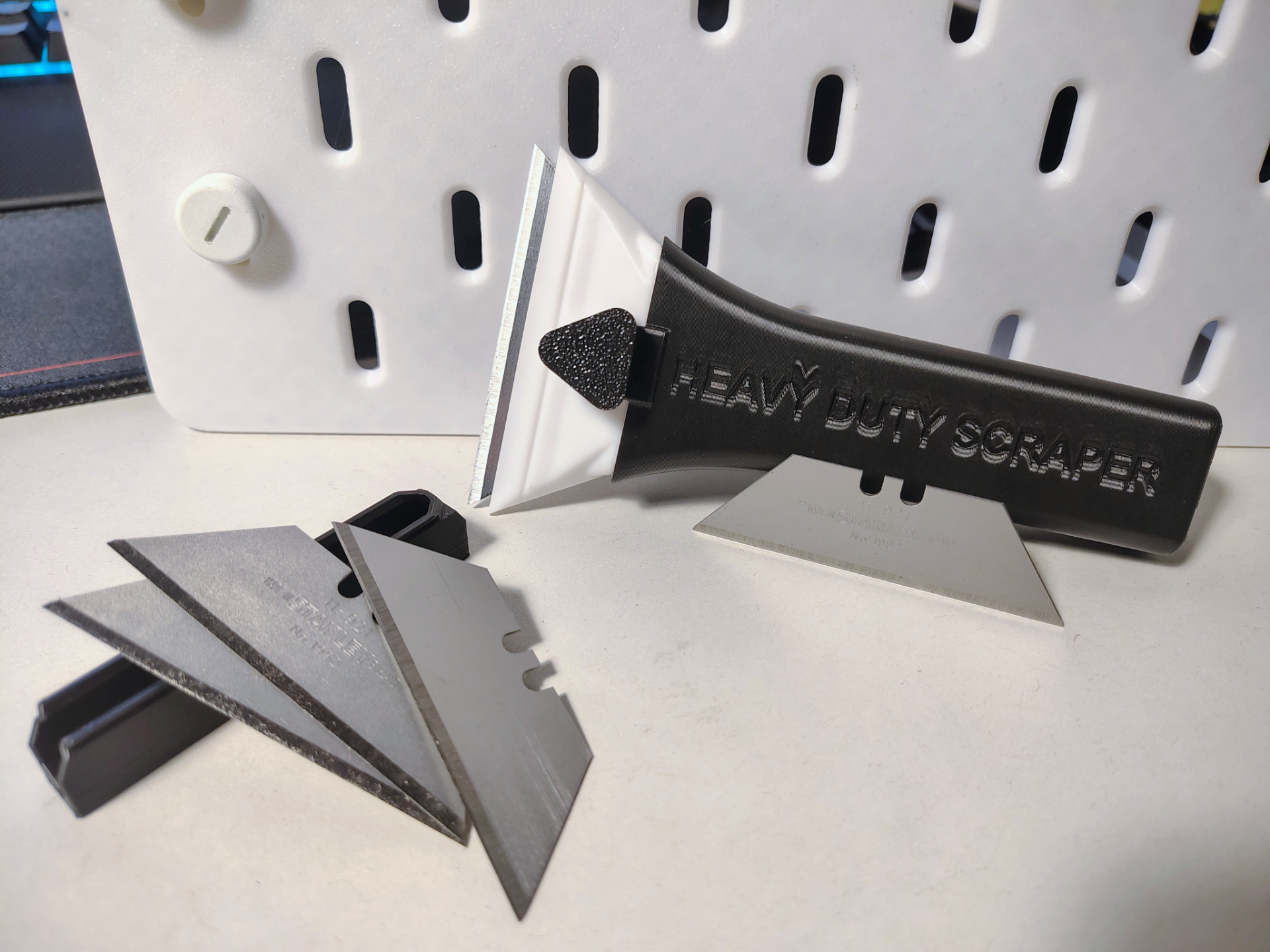 Trapezoidal blade scraper with blades storage