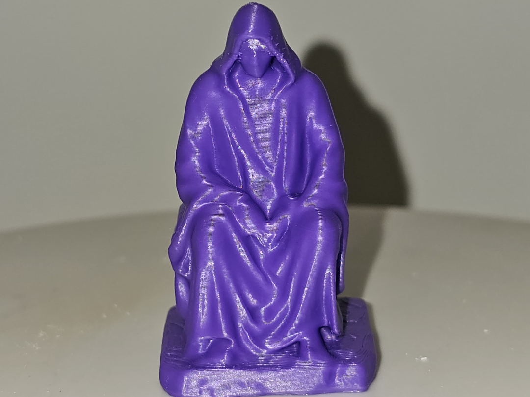 Hooded man sitting on rock