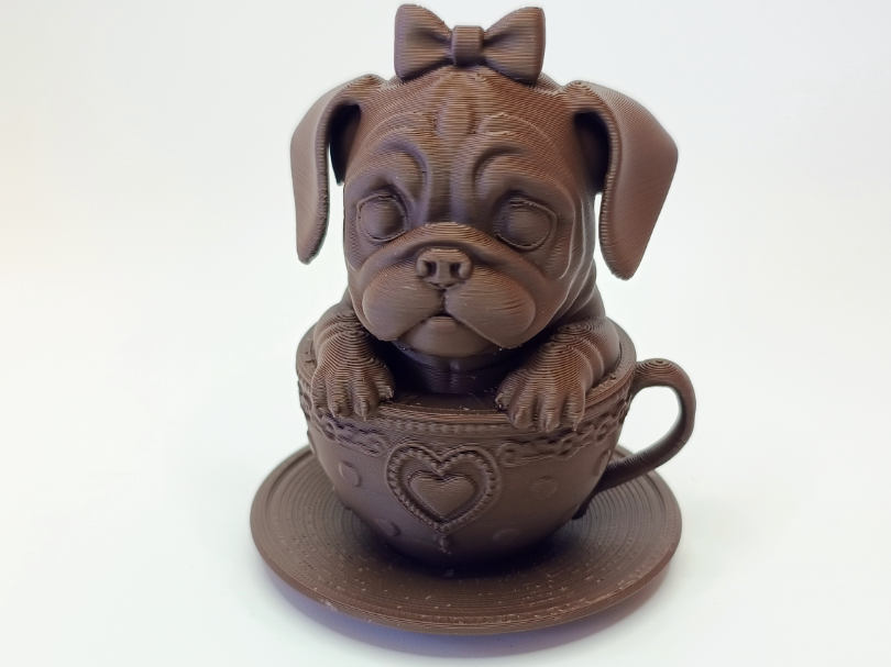 Suesser Mops in Tasse mit Schleife und Herz
