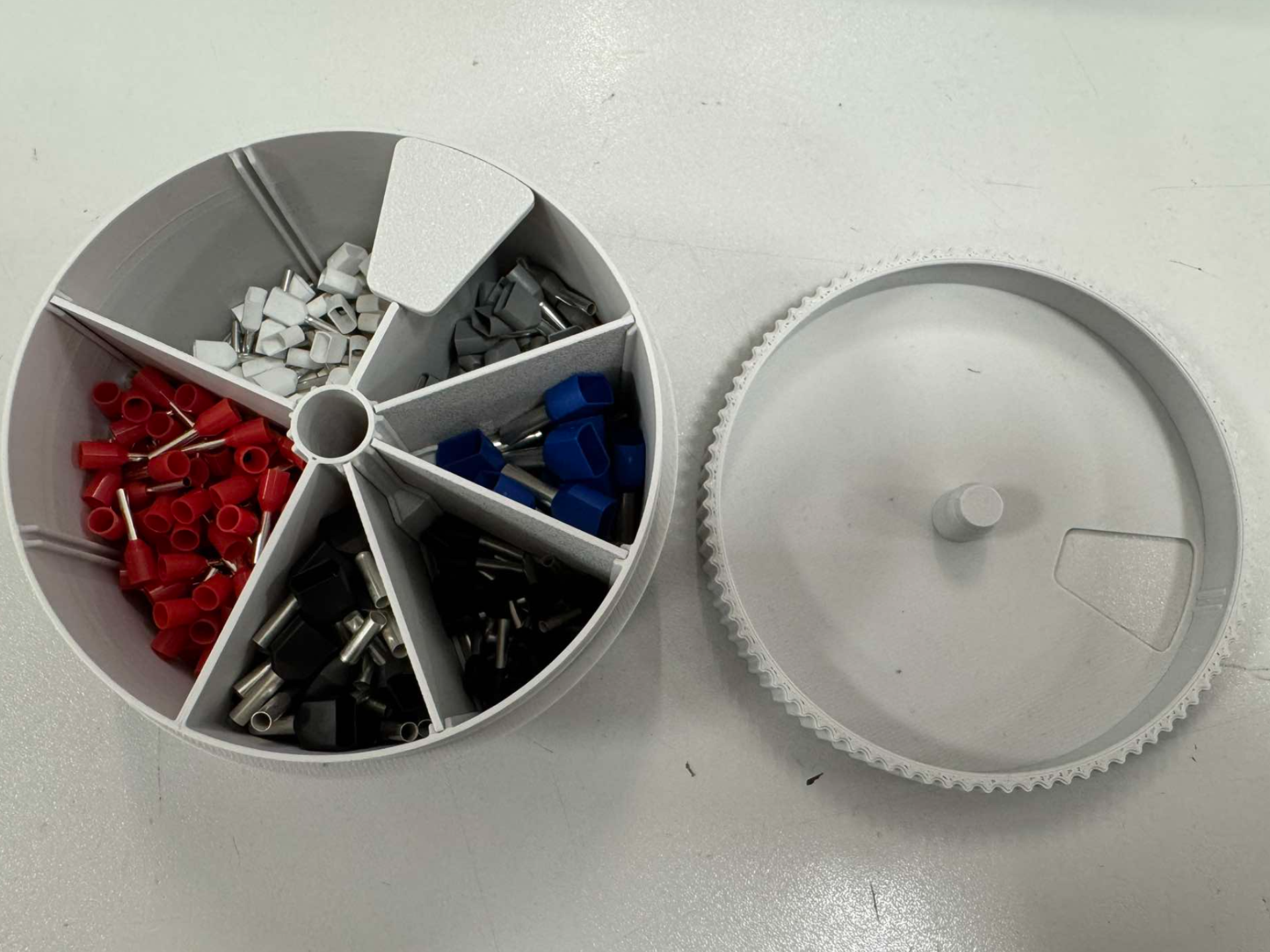 Box for small parts with spacers and rotating lid