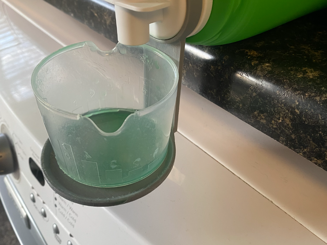 Dispensing cup holder for detergent bottles