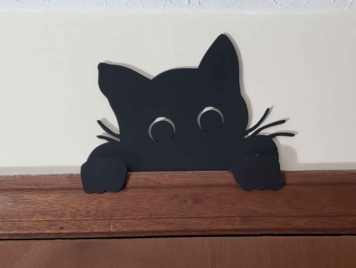 Cat peeking over the door frame